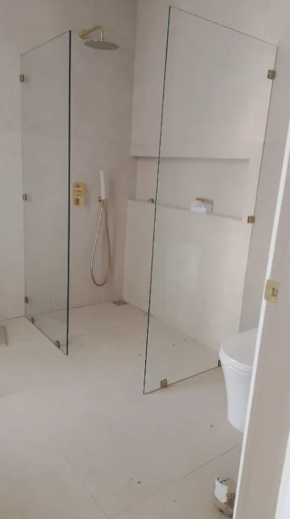 Dos paneles transparentes de vidrio instalados en una ducha abierta.