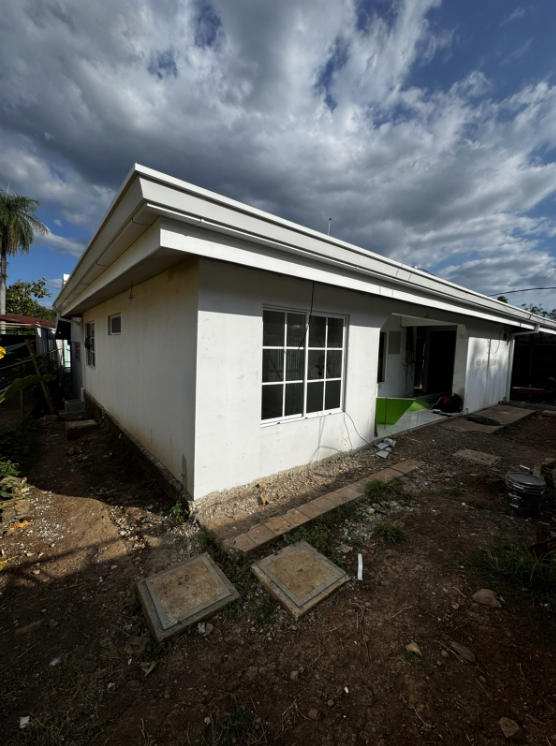 Vista exterior de vivienda con ventana de cuadrícula blanca.