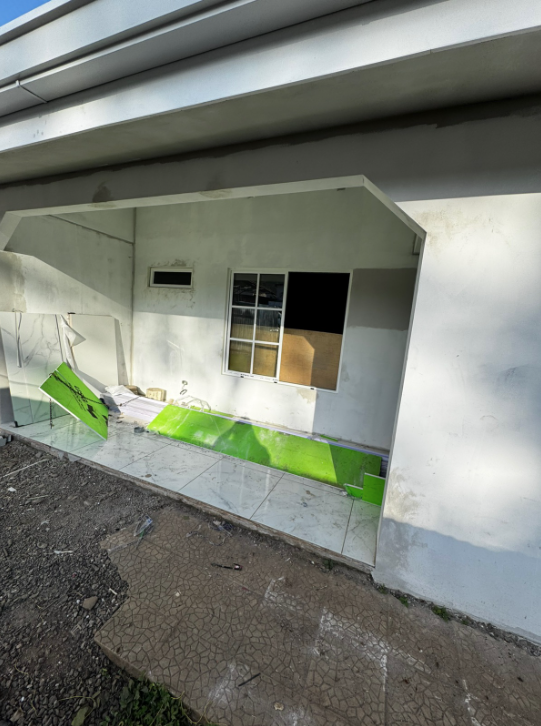 Ventana con moldura de cuadrícula en el corredor de una vivienda en proceso de obra.